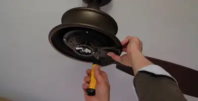 Electrician installing ceiling fan mounting bracket and fixture in Lancaster, PA