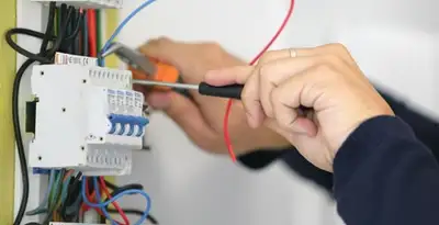 Electrician installing and adjusting circuit breakers in an electrical panel in Lancaster, PA
